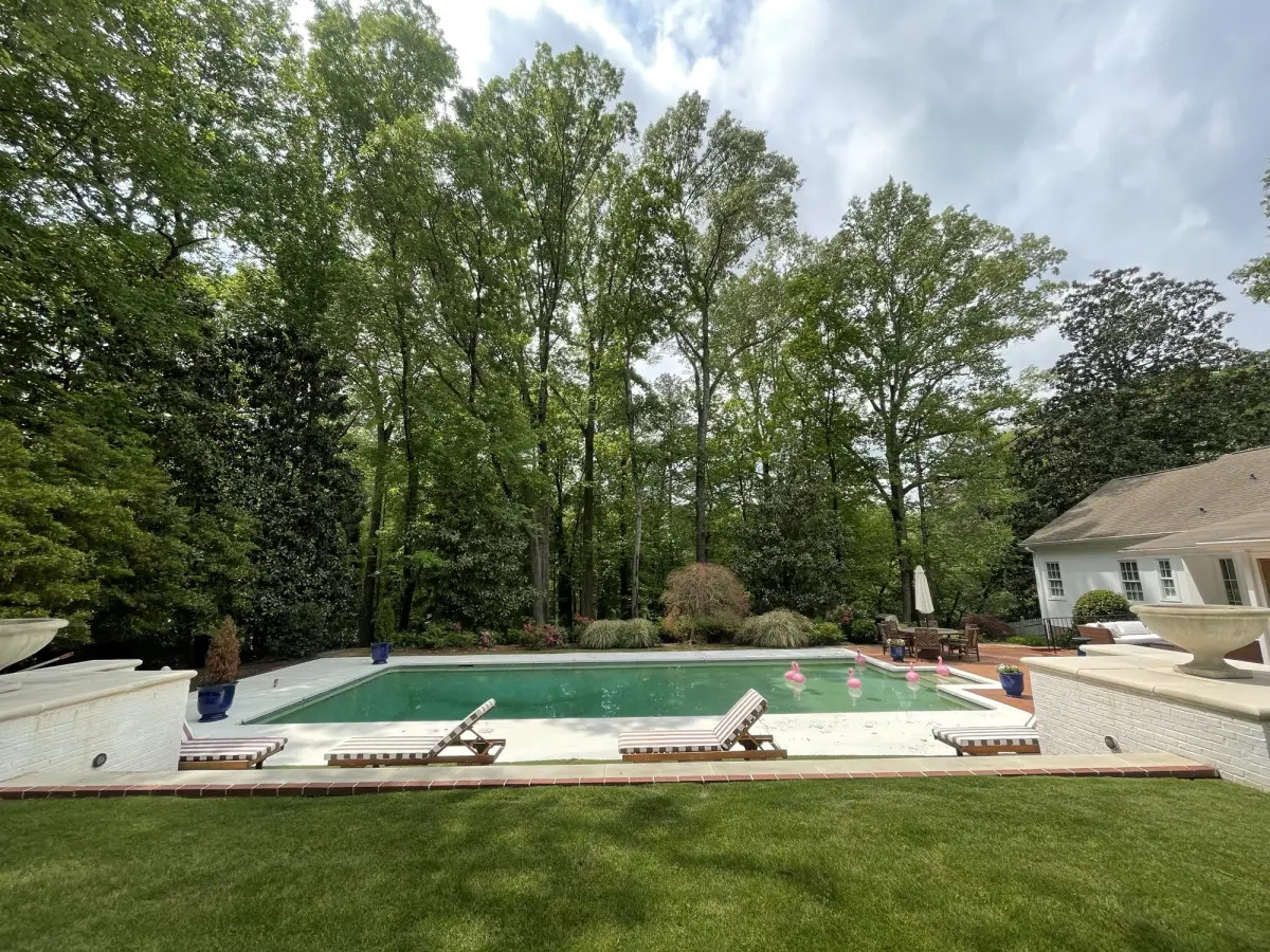Classic backyard pool framed by lush lawn