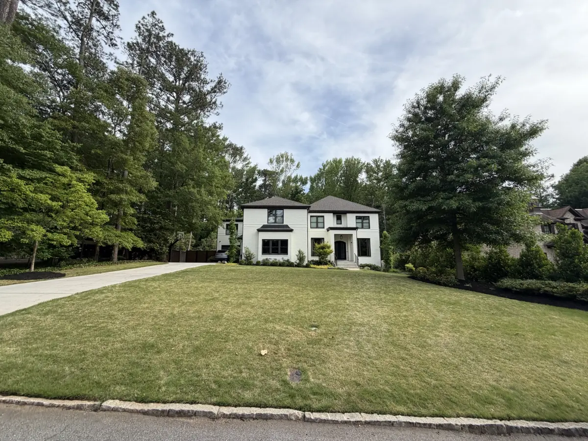 Wide street view of a manicured front lawn